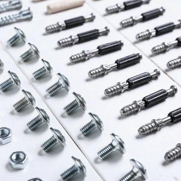 Different types of self-clinching fasteners lined up on a white sufrace